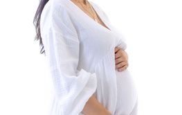 Portrait of an attractive young pregnant woman in a white...
