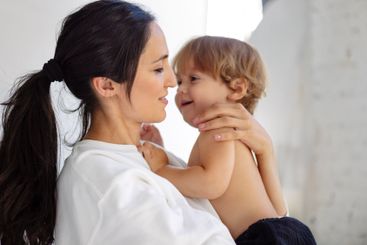 Close-up portrait of cute toddler with charming mom in...