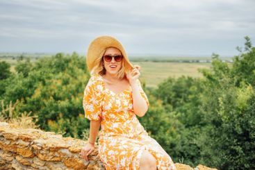Attractive girl in pink dress and wide brimmed straw hat...