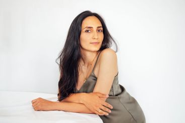 A portrait of an attractive young woman in a green satin...