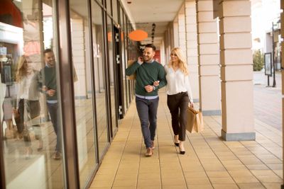 Portrait of young couple with shopping bags in city