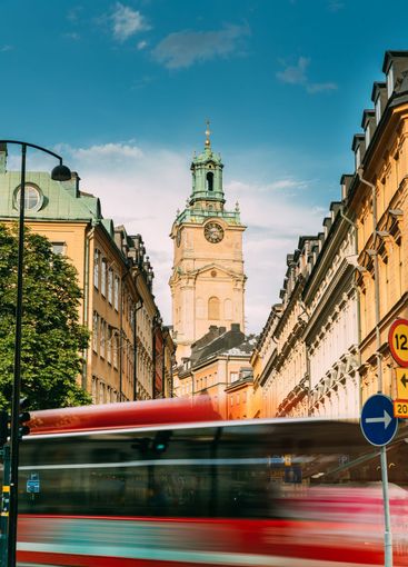 Stockholm, Sweden. Red Bus In Motion Blur Rides Near Old...