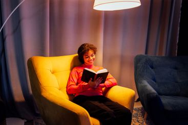 Young laughing African woman in sweater is sitting in...