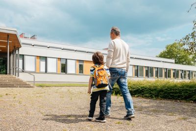 Dad escorts his child to school or kindergarten for the...