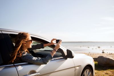 happy teenage girl or young woman in car