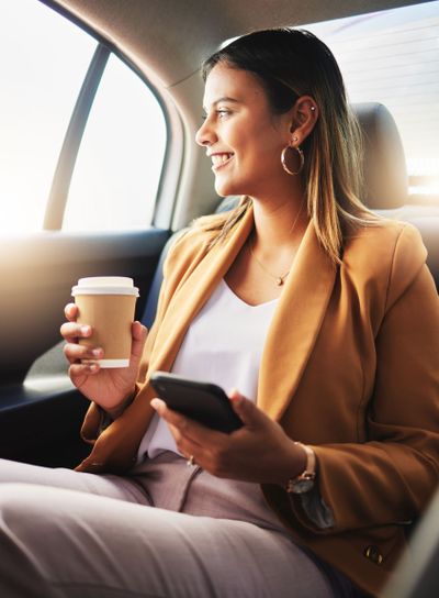 Businesswoman, phone and coffee in car for travel to...