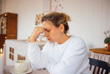 Amidst the gentle glow of candlelight, she sits in...