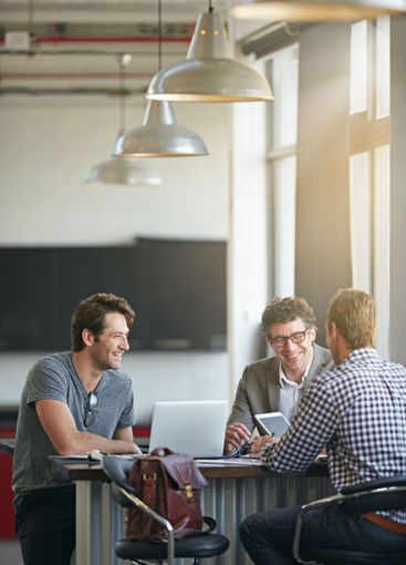 Colleague, laptop and talking in office for web project,...