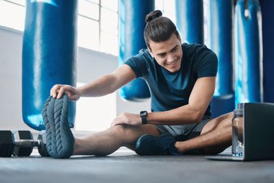 Stretching, fitness and a man with a laptop for exercise...