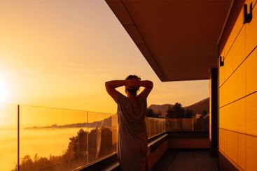 Young woman in a dress is enjoying the sunrise. The lady...